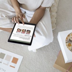 woman holding an ipad on the s creen is apage from a guide by TCB Social Media called Turn Your Content into Customers